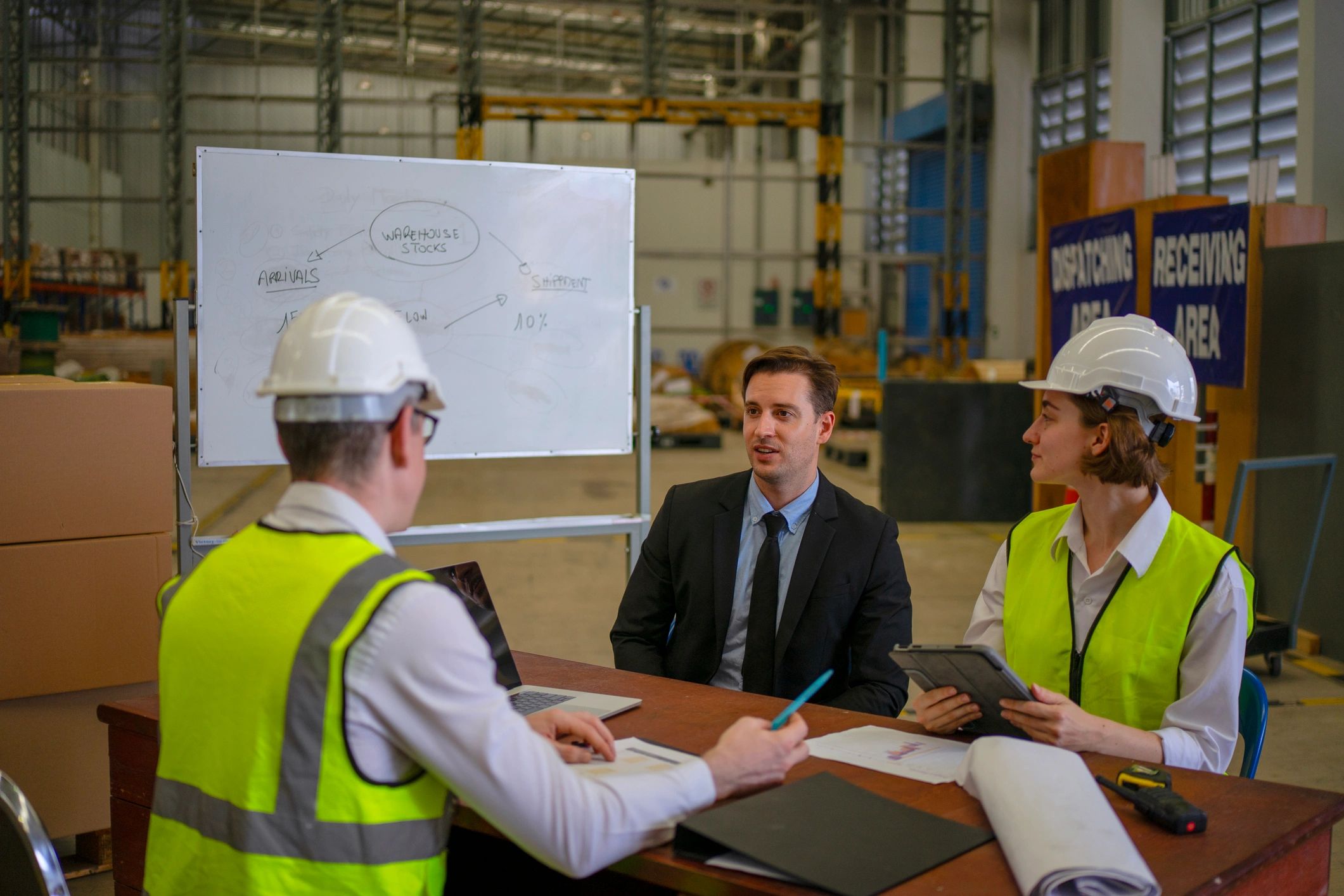 Blue collar workers meeting in an industrial warehouse
